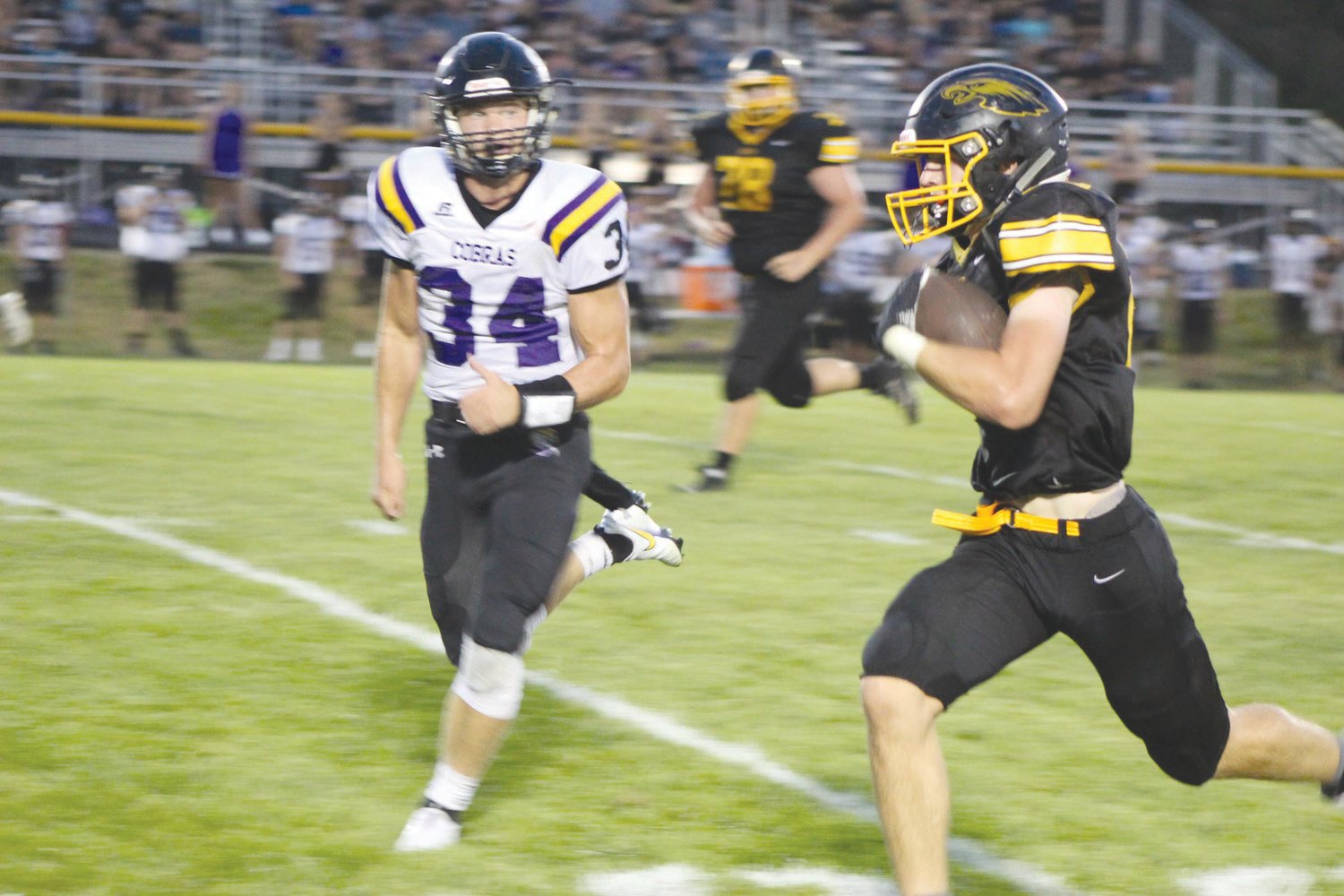 Mid-Prairie running back Kayden Reinier sprints past Sigourney Keota’s Brady Duwa for a long gain late in the first half of Friday night’s season opener in Wellman. Reinier rushed for 134 yards and two TDs.